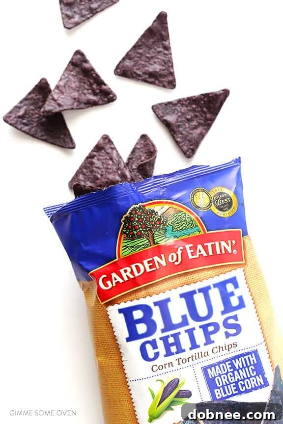 A vibrant bowl of pineapple guacamole with fresh cilantro and lime wedges, ready to be served.