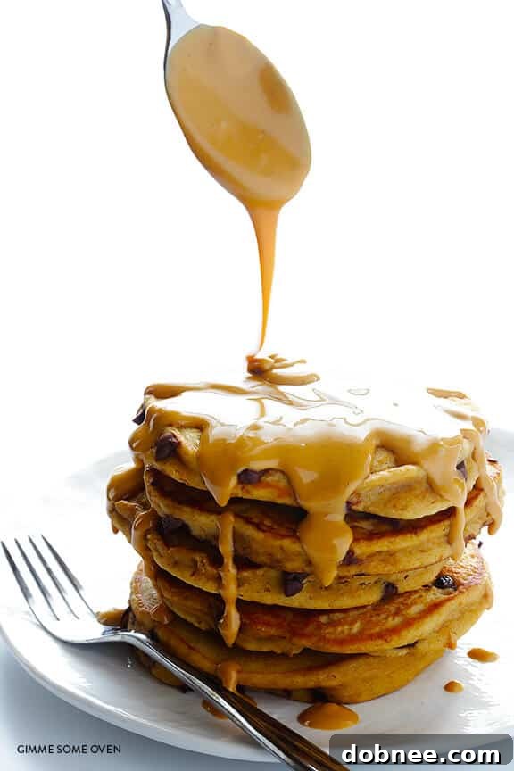 Pancakes cooking on a skillet, with chocolate chips melting on top