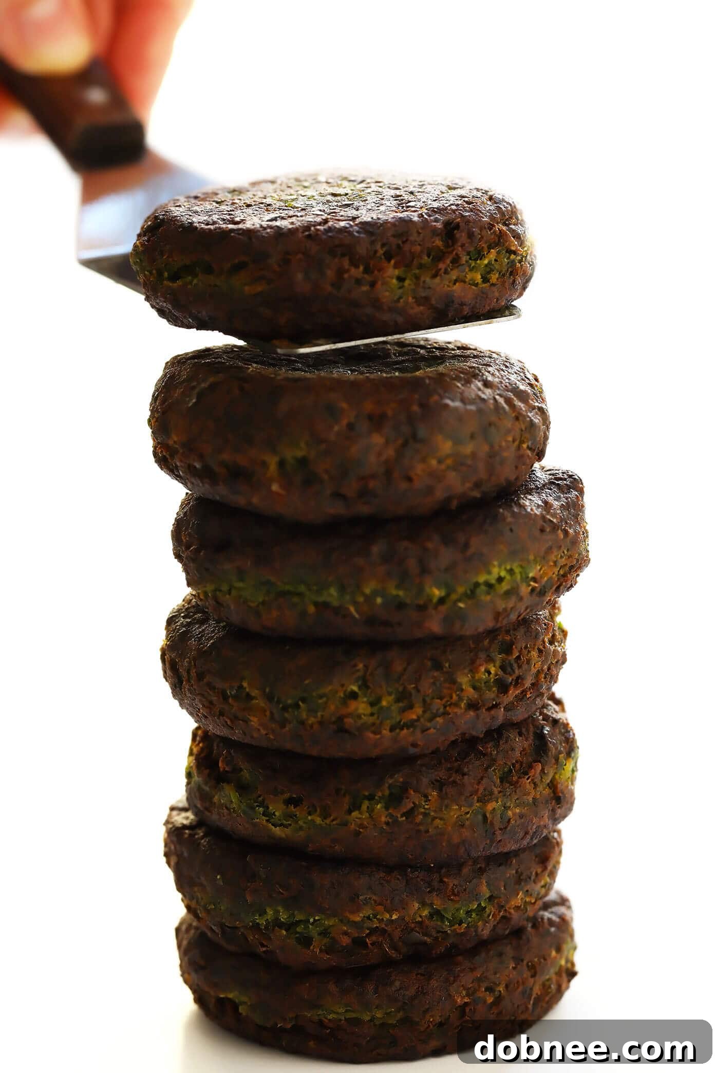 Easy Pan-Fried Falafel Recipe - Golden brown, crispy falafel patties cooling on a paper-towel lined plate.