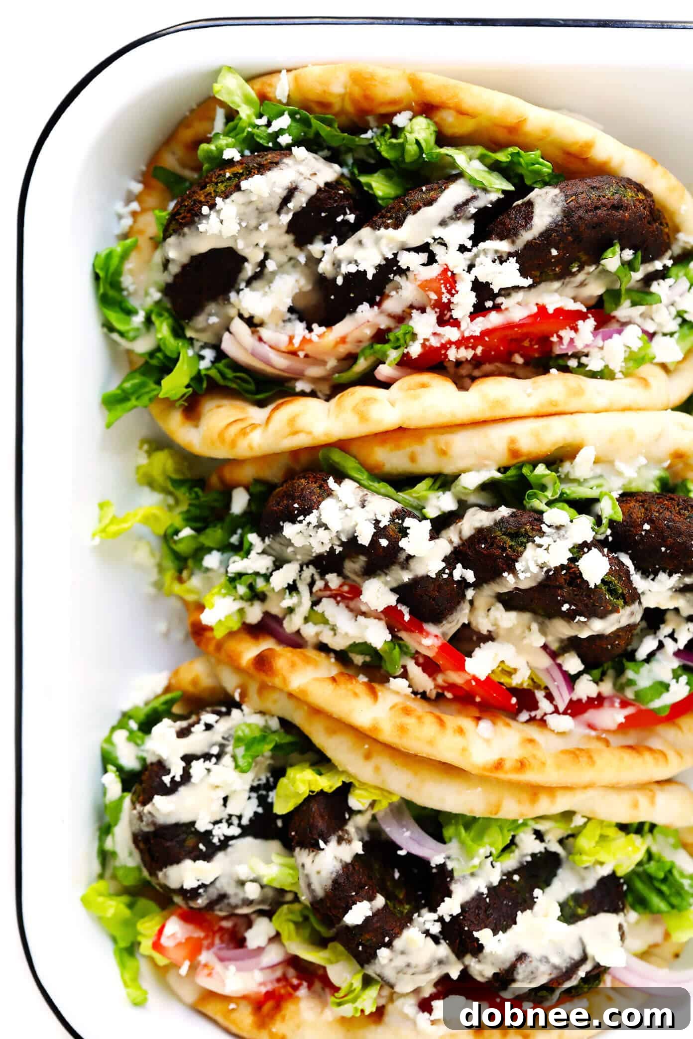 Delicious Falafel Sandwiches in Pita Wraps - Served with fresh vegetables and creamy sauces.