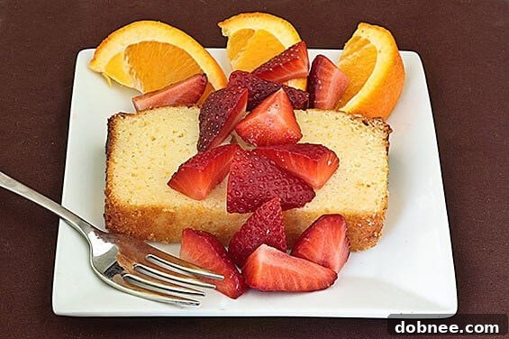 Delicious Orange Ricotta Pound Cake topped with fresh strawberries, ready to be served