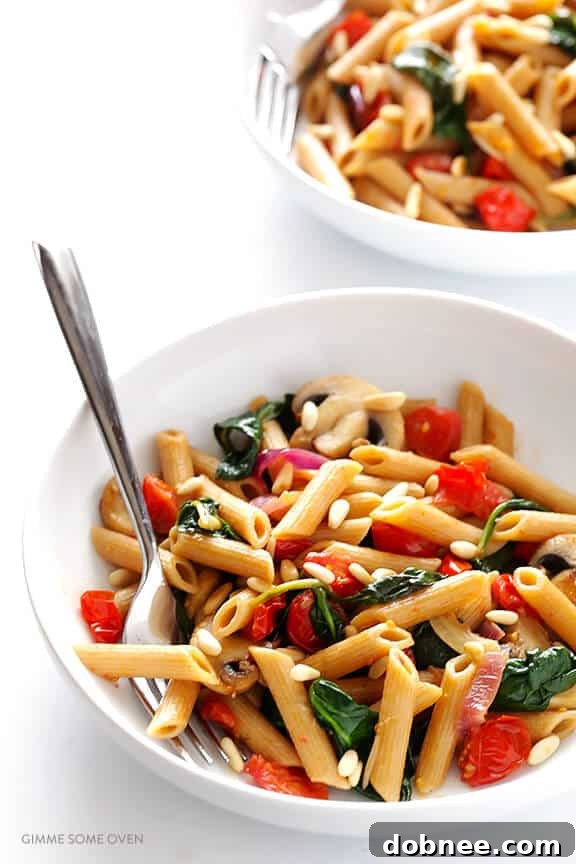 Close-up of freshly cooked Pasta with Mushrooms, Tomatoes & Spinach – an easy and quick vegetarian recipe. Perfect comfort food with a simple white wine sauce. | dobnee.com