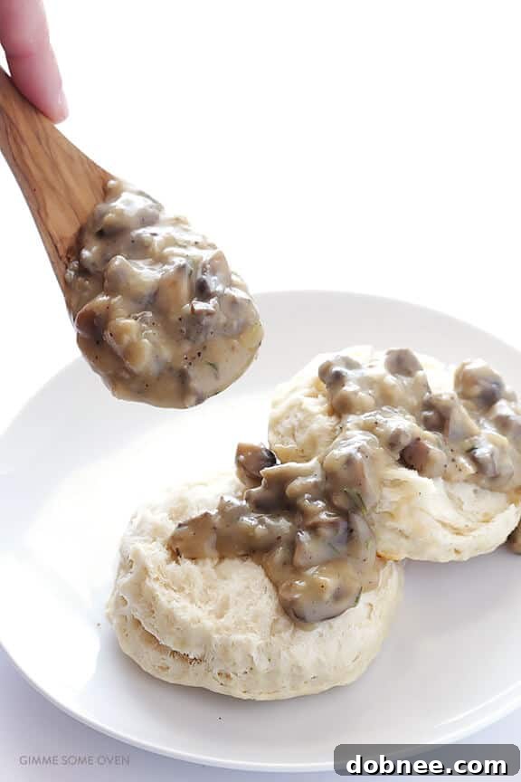 Warm vegan mushroom gravy generously spooned over fluffy biscuits.