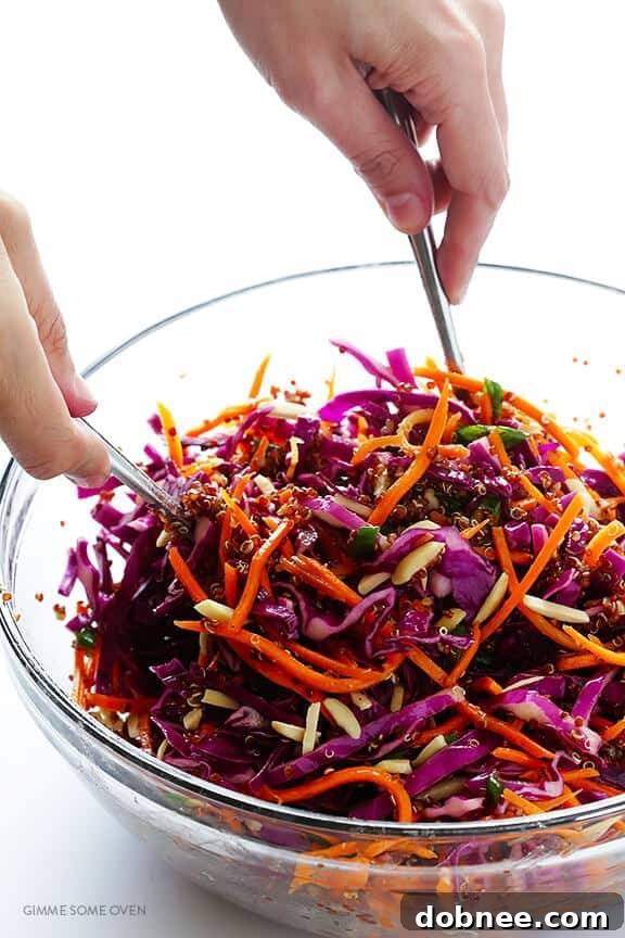 The sesame vinaigrette being poured over the mixed ingredients of the Easy Asian Quinoa Salad.