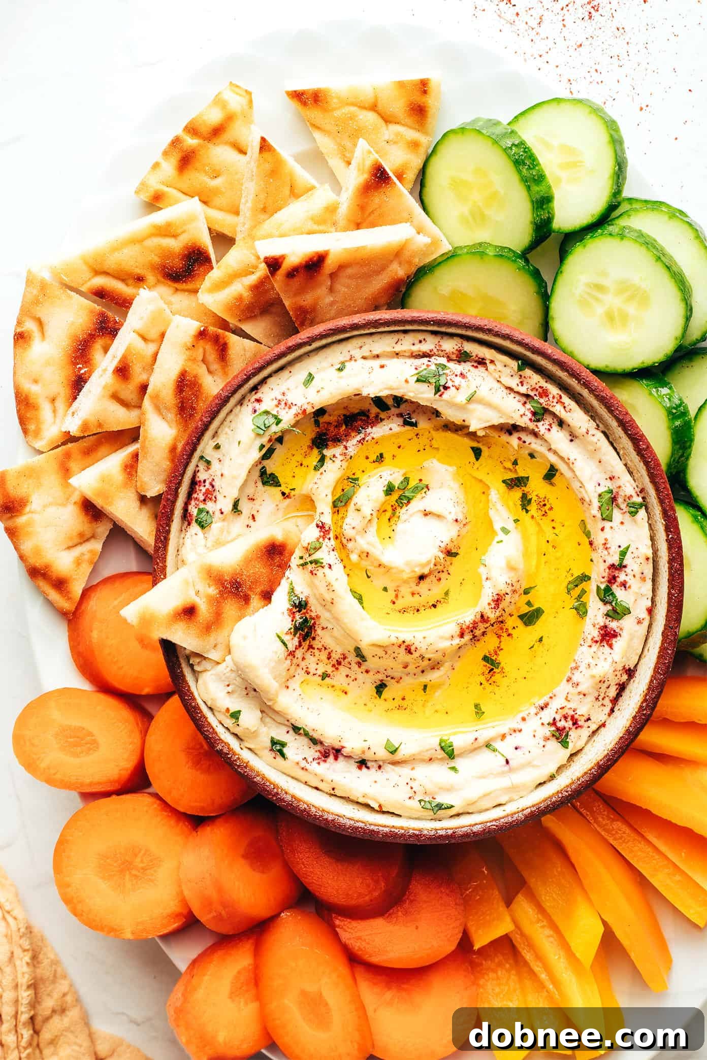 Deliciously creamy homemade hummus served in a bowl with a drizzle of olive oil and a sprinkle of sumac