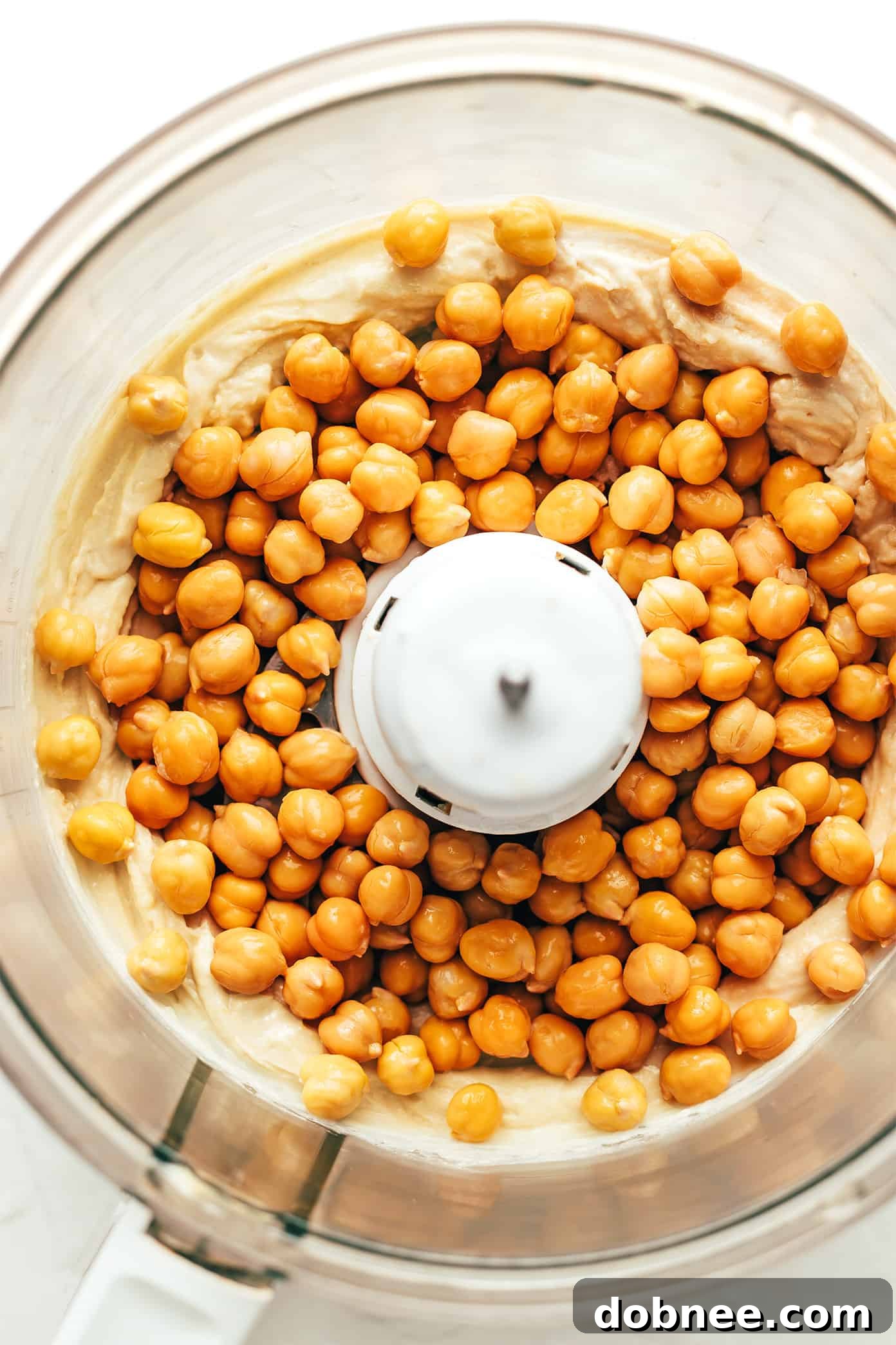 A bowl of homemade hummus served with pita bread and fresh vegetables for dipping.
