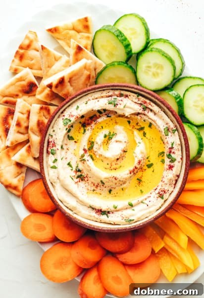 Close-up of the smooth and creamy homemade hummus in a white bowl, garnished beautifully.