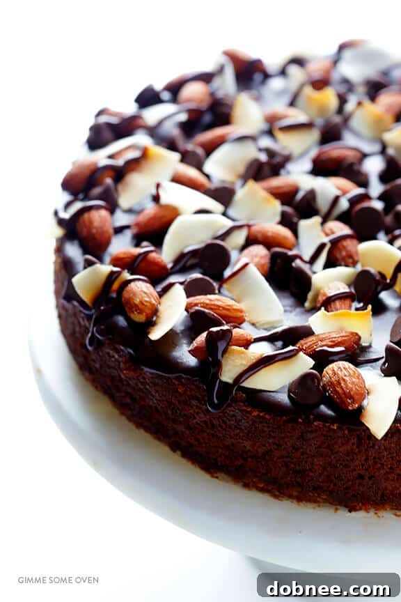 A slice of Almond Joy Cheesecake showcasing the layers of crust, filling, and generous toppings.