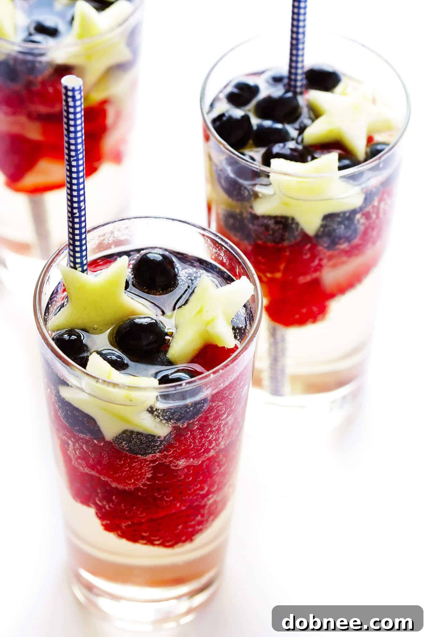 Vibrant Sparkling Red, White, and Blue Sangria garnished with fresh fruit, perfect for patriotic celebrations like the 4th of July or Memorial Day. An easy and delicious summer cocktail recipe.
