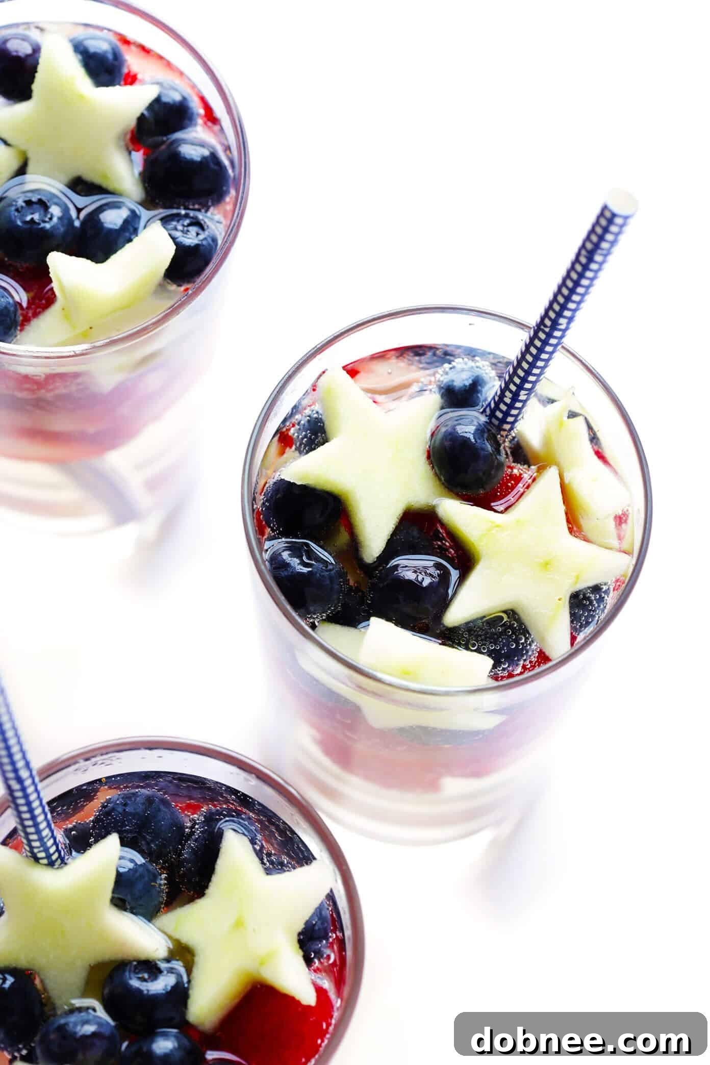 Full spread of Sparkling Red, White, and Blue Sangria ingredients and final drink, including a recipe card, perfect for a patriotic party on 4th of July or Memorial Day. Easy summer cocktail.