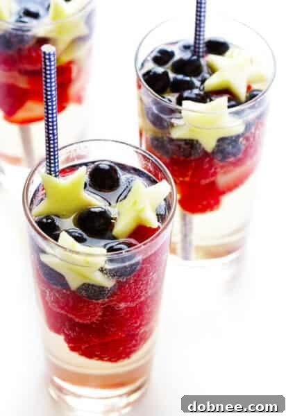 Sparkling Red, White, and Blue Sangria served in a glass with fresh fruit garnish.
