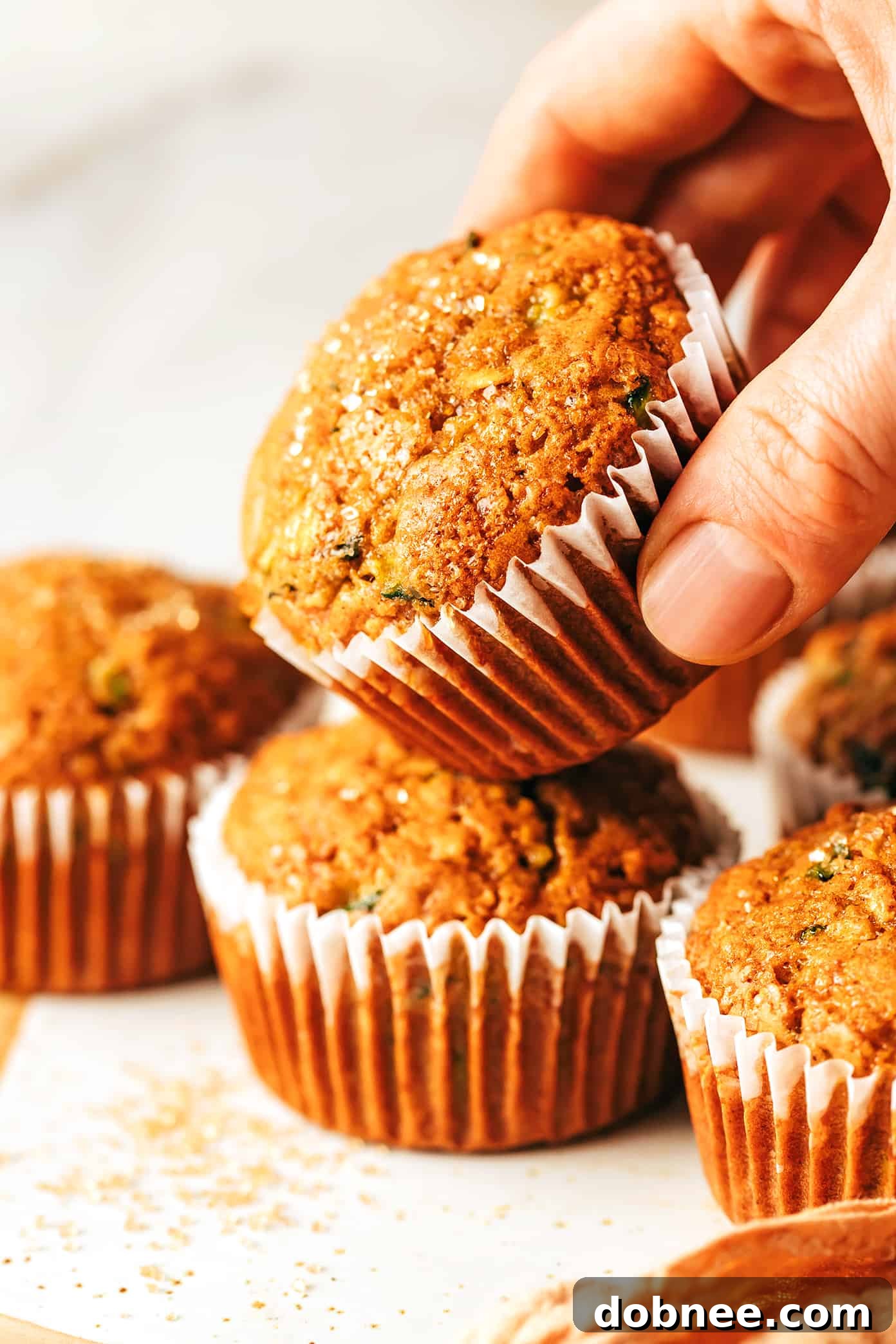 Freshly baked healthy zucchini muffins, golden brown and sprinkled with turbinado sugar, cooling on a rack.