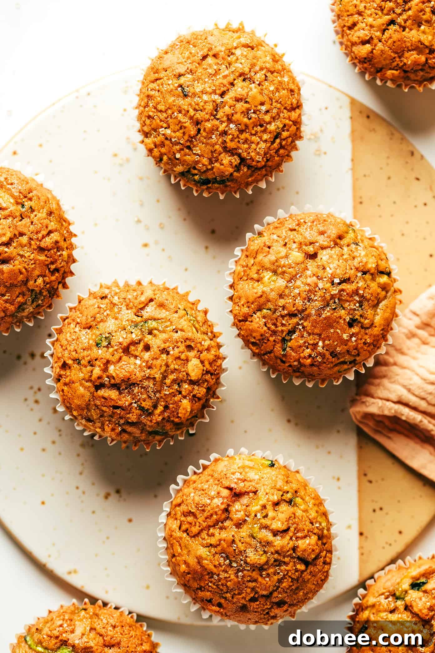 A single healthy zucchini muffin broken open, revealing its fluffy interior and hidden zucchini strands.