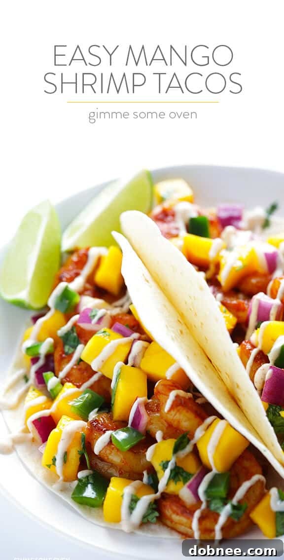 A vibrant, close-up shot of the finished Easy Mango Shrimp Tacos on a wooden board.