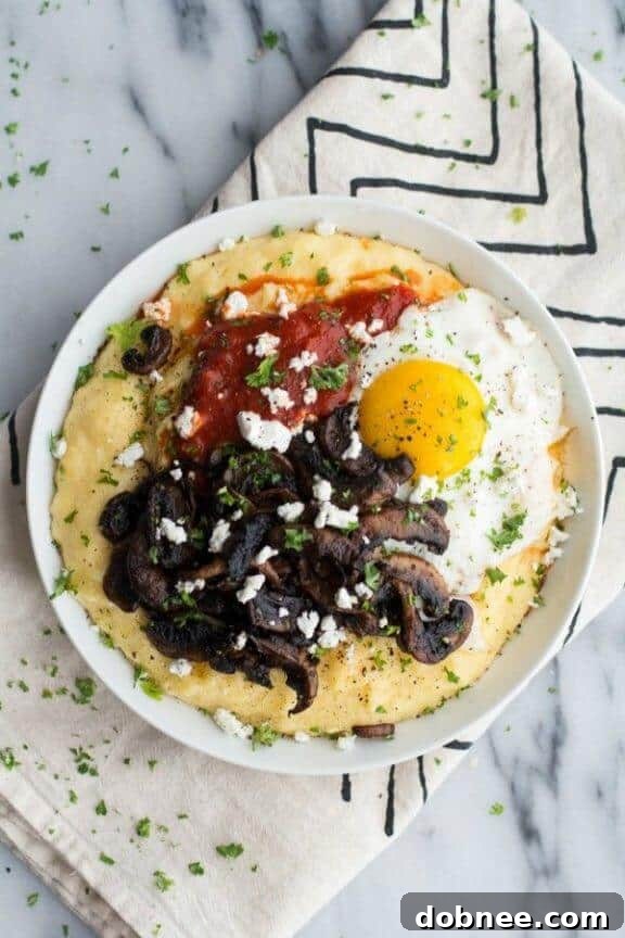 Creamy polenta topped with rich caramelized mushrooms, marinara sauce, a fried egg, and goat cheese for a gourmet vegetarian experience.