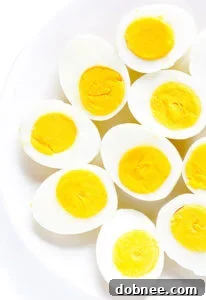A perfectly hard-boiled egg, sliced in half, showing a vibrant yellow yolk and tender white, ready for serving.