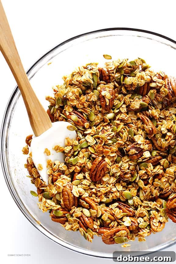 Mixing bowl with oats, nuts, and pumpkin spice mixture for granola