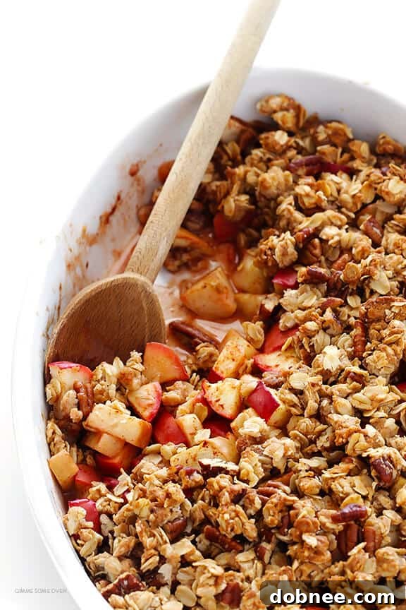 Freshly baked easy apple crisp, golden and bubbling, scooped into a bowl, showing its warm, comforting texture.