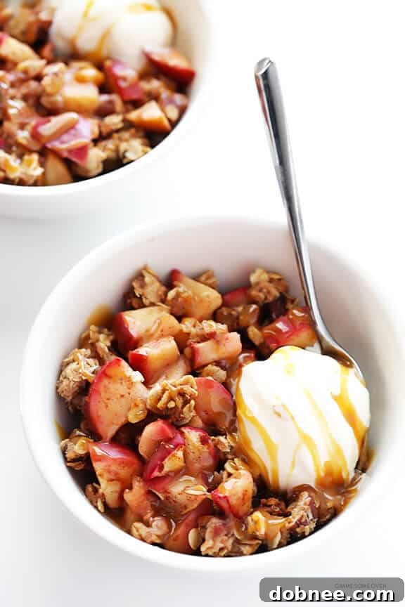 A serving of Easy Apple Crisp topped with a scoop of vanilla ice cream and a drizzle of caramel sauce, ready to be enjoyed.