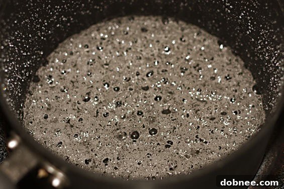 Close-up of fluffy Vanilla Almond Cupcakes adorned with a swirl of luxurious Salted Caramel Buttercream, showcasing its smooth texture.