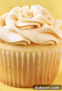 Stacked vanilla almond cupcakes with salted caramel buttercream, garnished with sea salt flakes.