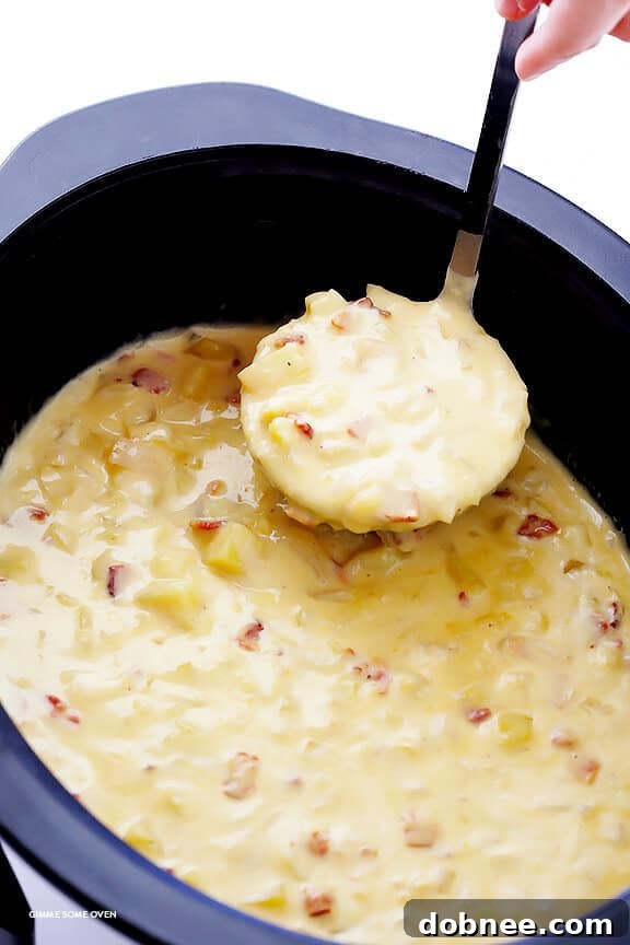 Deliciously creamy Slow Cooker Potato Soup served in a bowl with fresh herbs and bacon bits