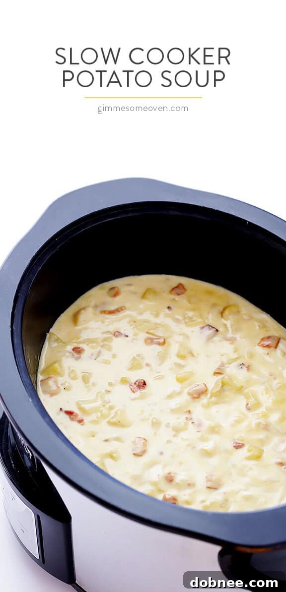 A steaming bowl of Slow Cooker Potato Soup garnished with fresh chives and crispy bacon bits, ready to eat