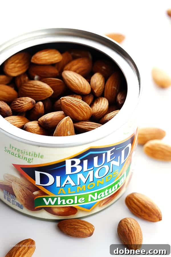 A plate of perfectly golden Almond-Crusted Chicken Nuggets with a side of dipping sauce, showcasing their crispy texture.