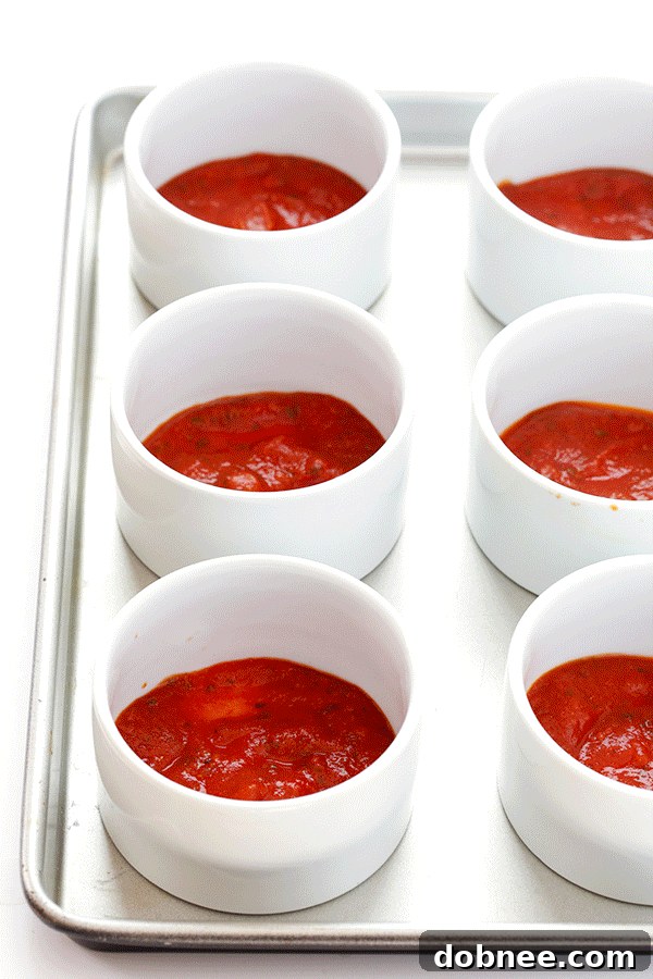 Layering ingredients for Quinoa Pizza Bowls – a simple method for a delicious and healthy meal.