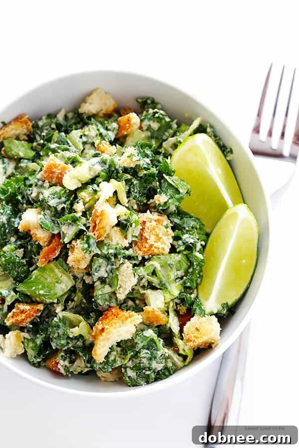 Close-up of a fresh Kale Caesar Salad being prepared, showcasing vibrant greens and dressing.