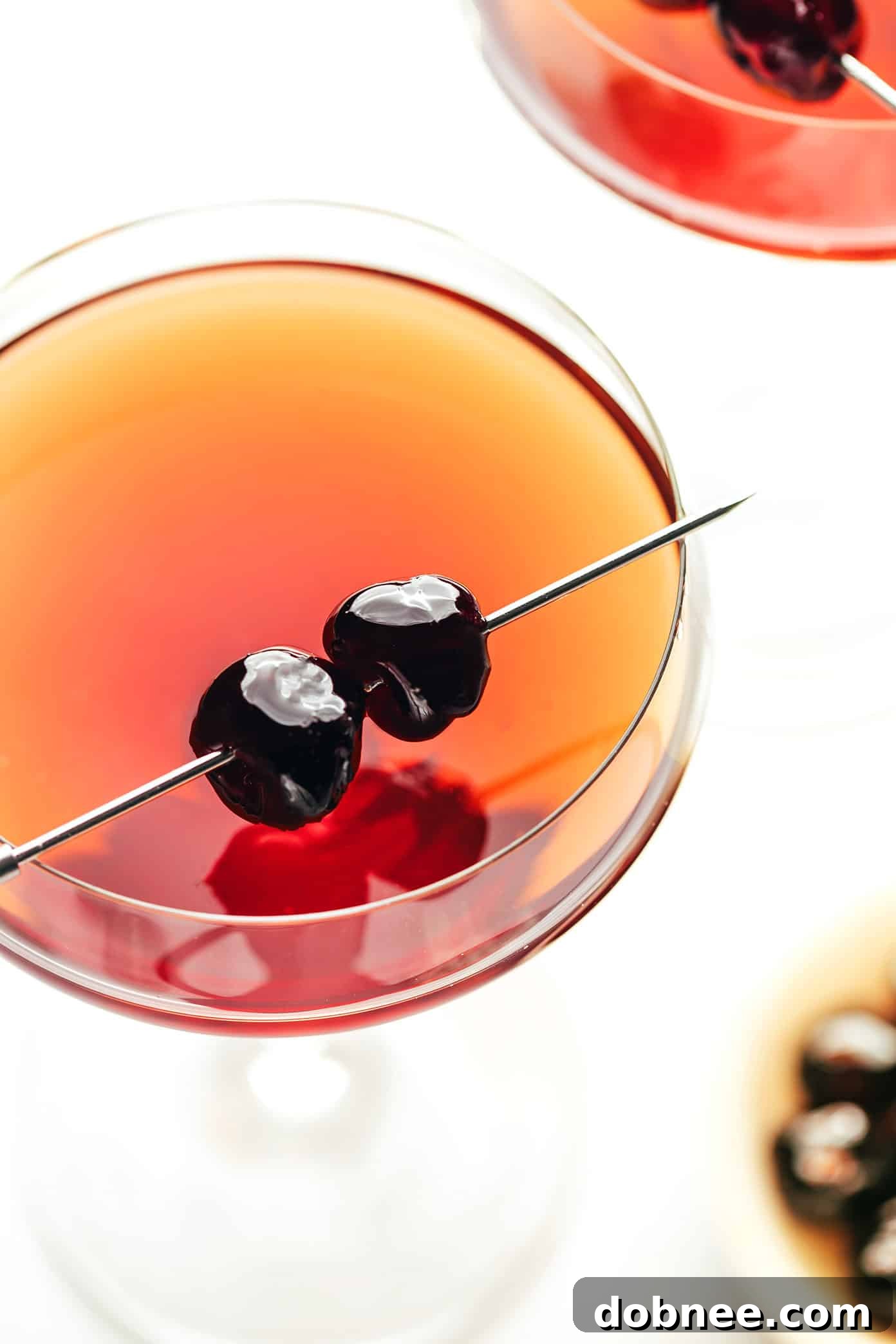 An elegant Manhattan cocktail being stirred in a mixing glass with ice, showcasing the preparation process