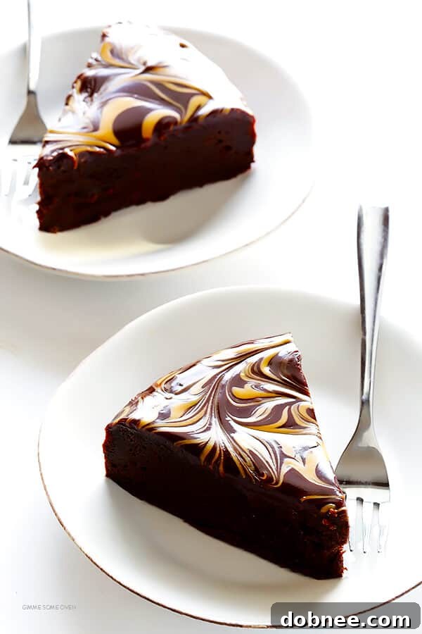 Slice of Peanut Butter Flourless Chocolate Cake on a white plate, revealing the dense chocolate interior and a clear view of the ganache swirl.