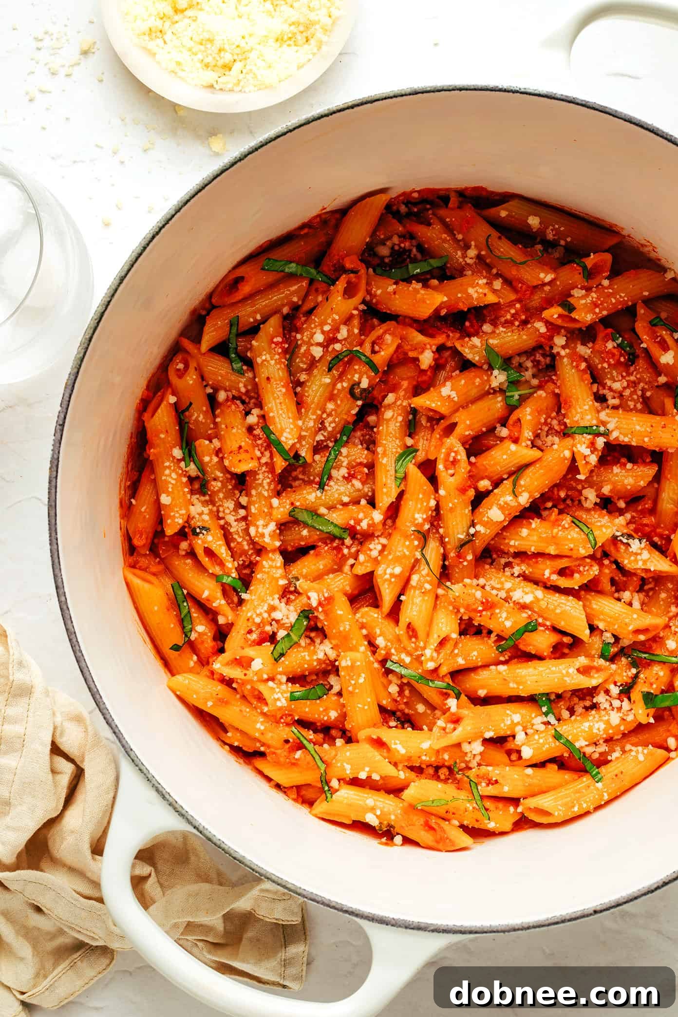 Vodka being poured into a hot pan with sautéed aromatics, forming the base of the creamy sauce.
