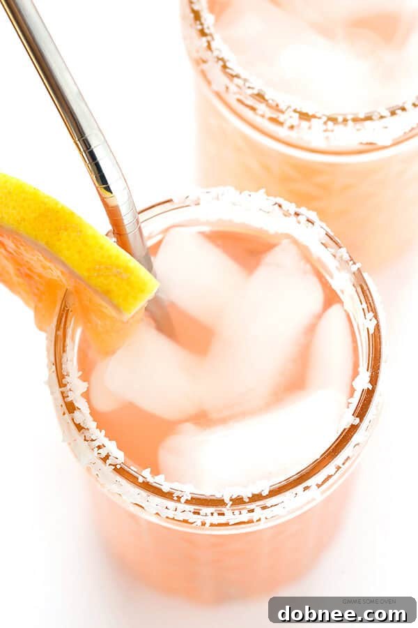 Close-up of a beautifully mixed Grapefruit Margarita cocktail with ice and a fresh grapefruit slice garnish