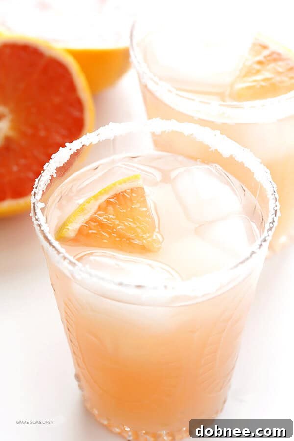 Two freshly made Grapefruit Margaritas on a serving tray with lime and grapefruit wedges, ready for enjoyment