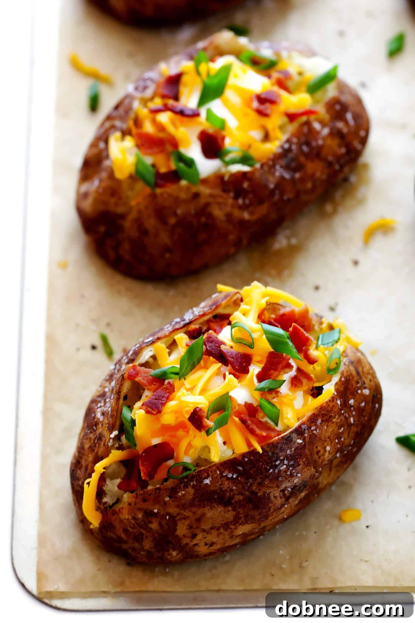 A selection of delicious loaded baked potatoes with various toppings like cheese, bacon, sour cream, and chives.