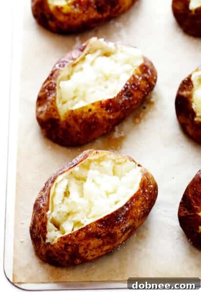A perfectly baked potato, sliced open and ready for toppings, showcasing its fluffy interior and crispy skin.