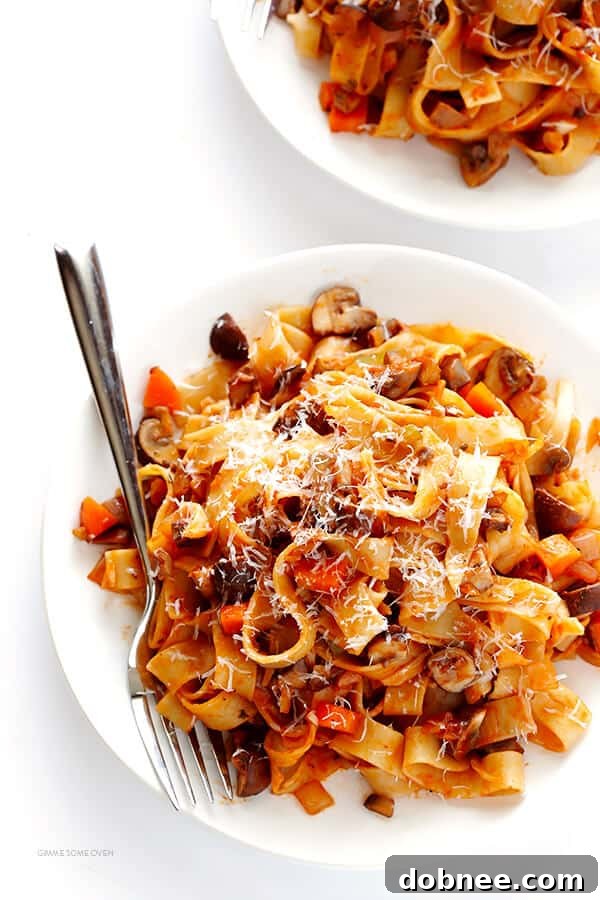 A bowl of hot, freshly served Mushroom Bolognese garnished with grated Parmesan cheese, ready to be enjoyed.