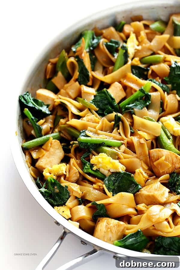 Freshly cooked Pad See Ew noodles with tender chicken and vibrant Chinese broccoli, glistening with a rich, savory-sweet sauce.