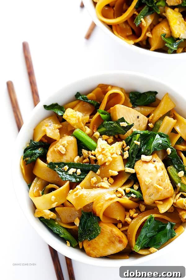 Close-up of freshly cooked Pad See Ew, showcasing the glossy noodles, green broccoli, and tender chicken, ready to be enjoyed.