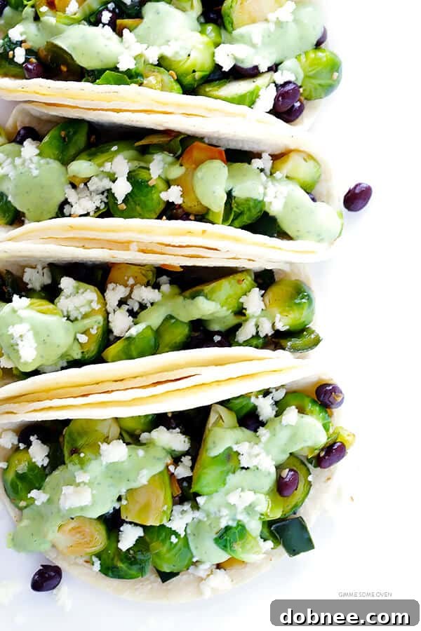 A close-up shot of a perfectly crafted Brussels Sprouts Taco, highlighting the fresh ingredients and creamy sauce. | gimmesomeoven.com