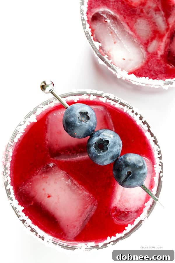 Refreshing Blueberry Margaritas ready to be enjoyed, garnished with lime and fresh blueberries.