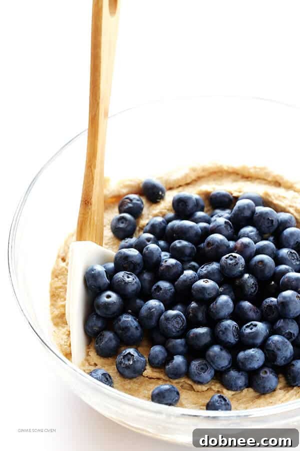 Close-up of Healthier Blueberry Muffins showing their light texture and fresh blueberries.