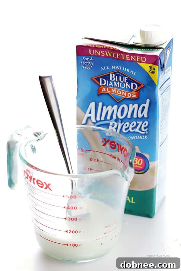 Scooping muffin batter into baking cups for Healthier Blueberry Muffins.