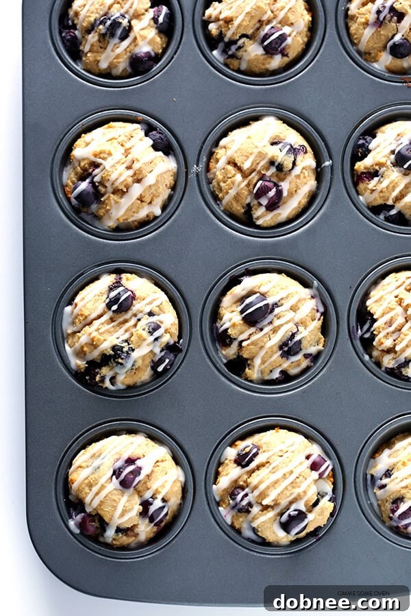 Drizzling honey lemon glaze over warm Healthier Blueberry Muffins.
