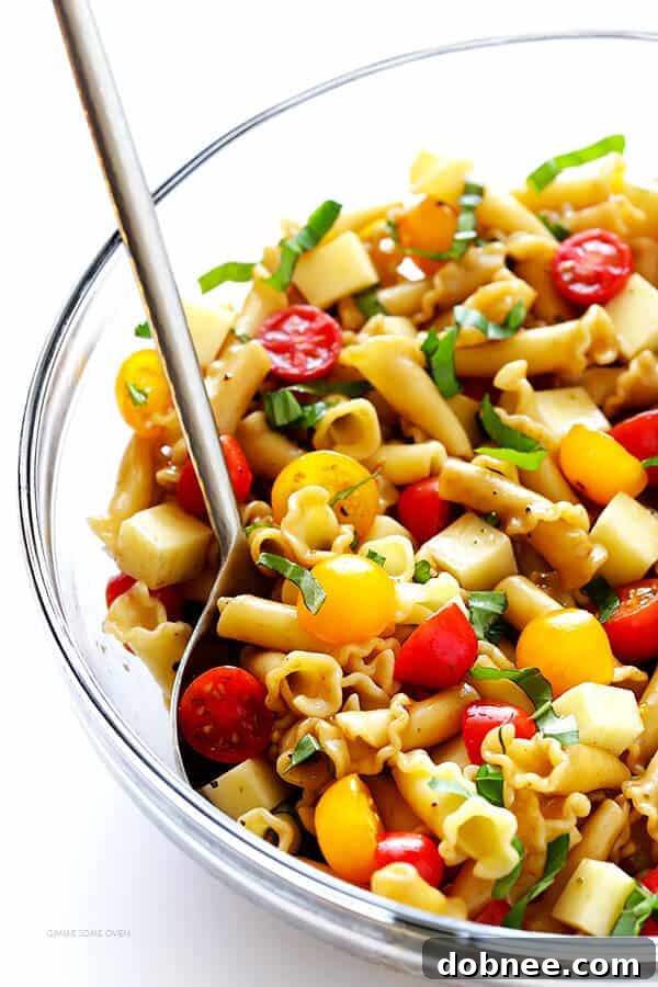Vibrant Caprese Pasta Salad with cherry tomatoes, fresh mozzarella, and basil, tossed in a balsamic vinaigrette, perfect for any occasion.