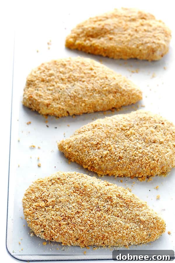 This Spicy Baked Chicken Parmesan recipe is made with a crispy seasoned panko crust, and topped with a spicy marinara sauce, melted mozzarella, and lots of fresh basil. It's surprisingly simple to make, and SO delicious! | gimmesomeoven.com