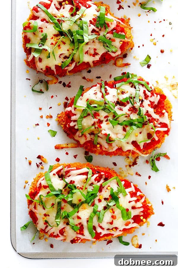 This Spicy Baked Chicken Parmesan recipe is made with a crispy seasoned panko crust, and topped with a spicy marinara sauce, melted mozzarella, and lots of fresh basil. It's surprisingly simple to make, and SO delicious! | gimmesomeoven.com