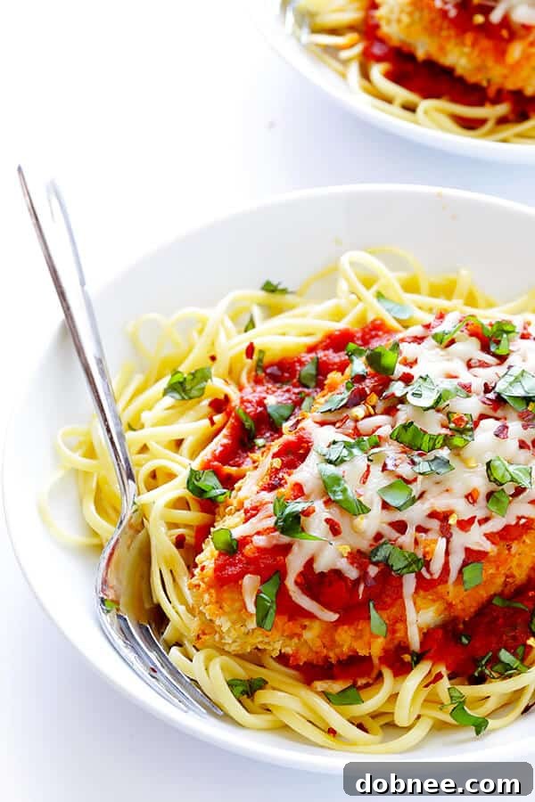 This Spicy Baked Chicken Parmesan recipe is made with a crispy seasoned panko crust, and topped with a spicy marinara sauce, melted mozzarella, and lots of fresh basil. It's surprisingly simple to make, and SO delicious! | gimmesomeoven.com