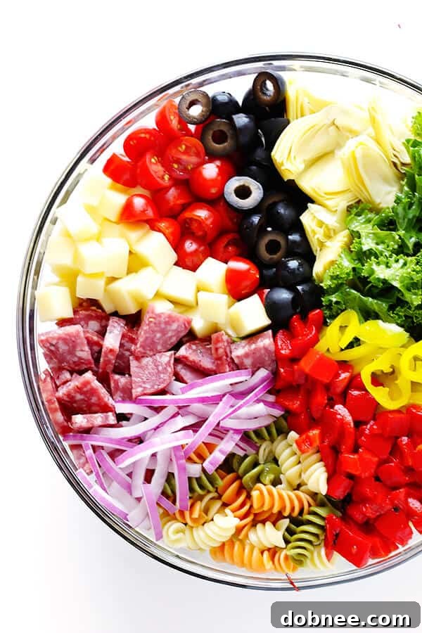 Diced salami, cheese, tomatoes, and olives ready for the pasta salad